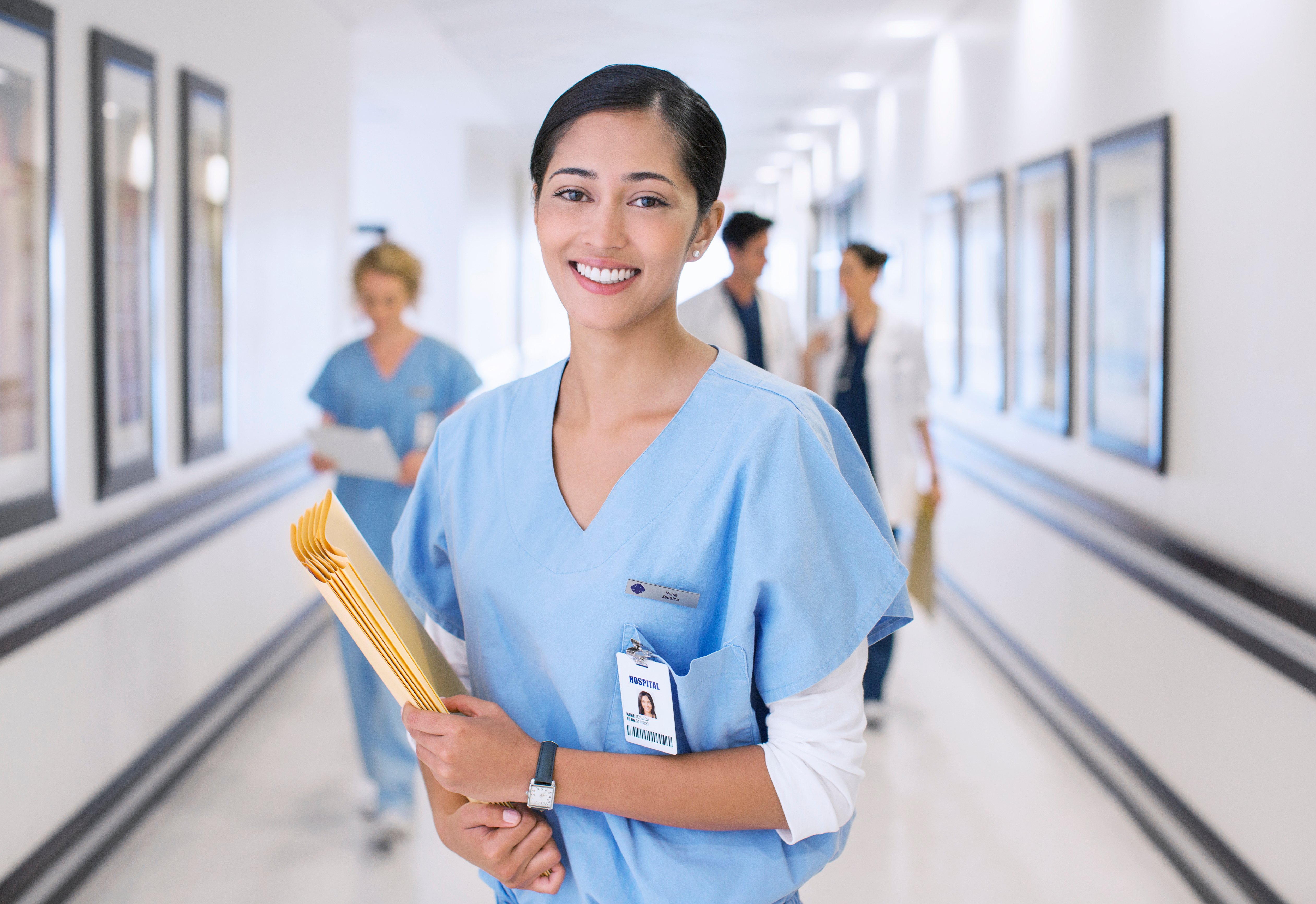 Nurse standing in a hallway holding files